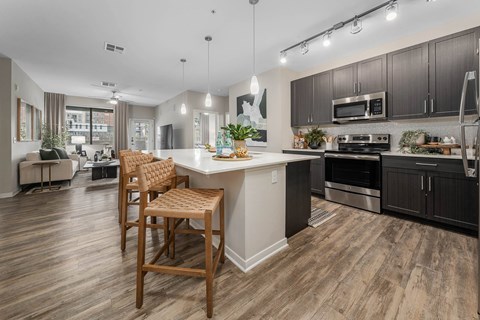 A modern kitchen with wooden floors and a large island.