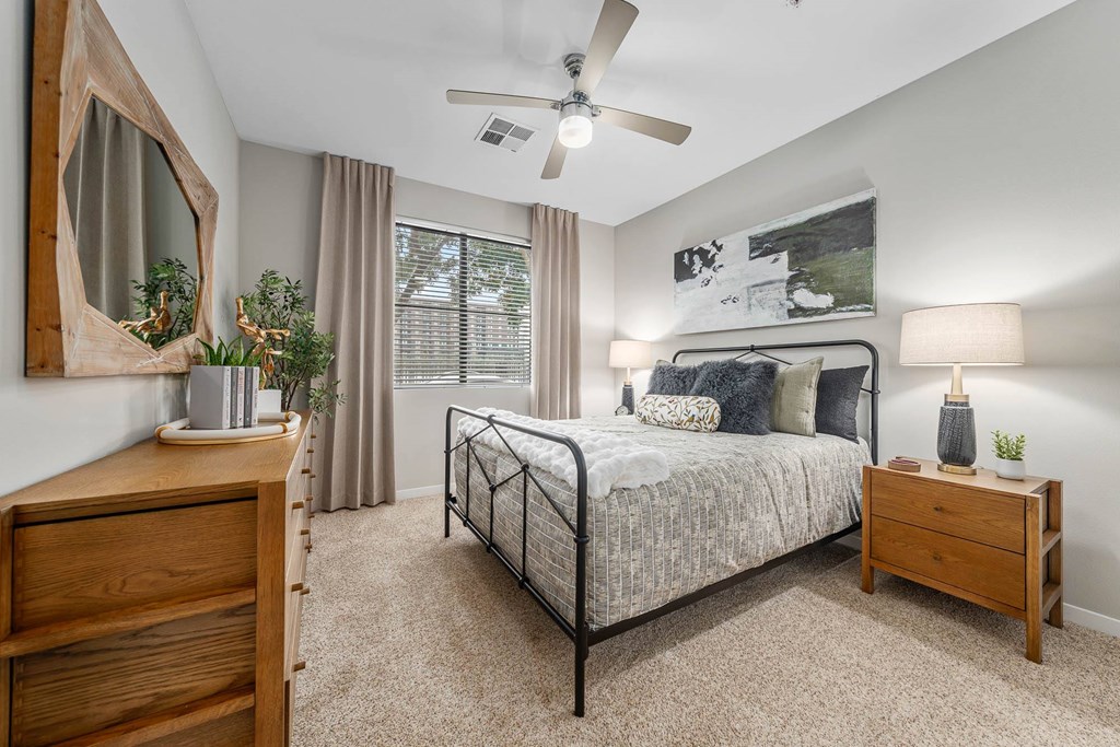 A bedroom with a bed, nightstand, and a dresser.