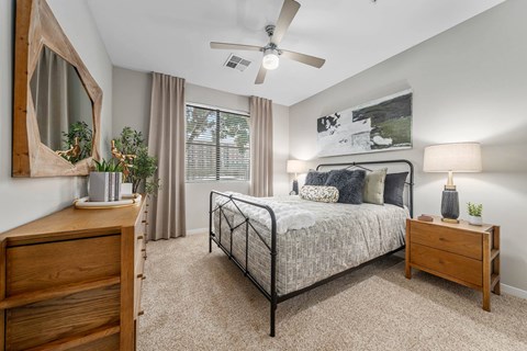 A bedroom with a bed, nightstand, and a dresser.