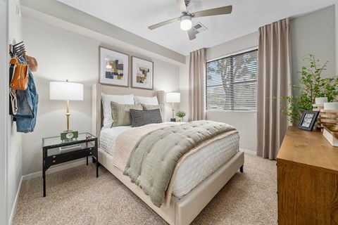 A bedroom with a large bed and a ceiling fan.