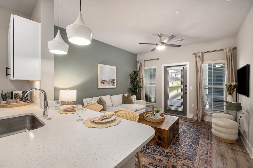an open kitchen and living room with a white counter top