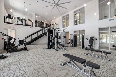 a gym with exercise equipment and a staircase