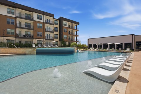 A modern pool with a fountain in the middle of it.