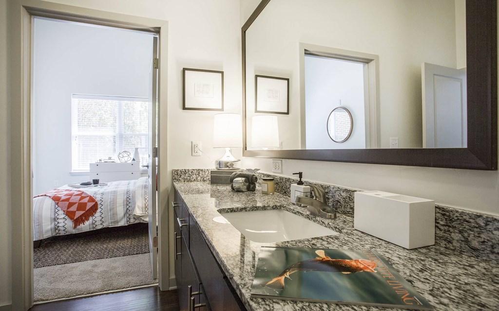 A bathroom with a sink, mirror, and a window.