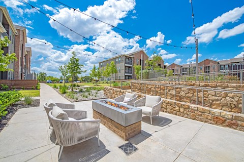 an outdoor patio with chairs and a fire pit