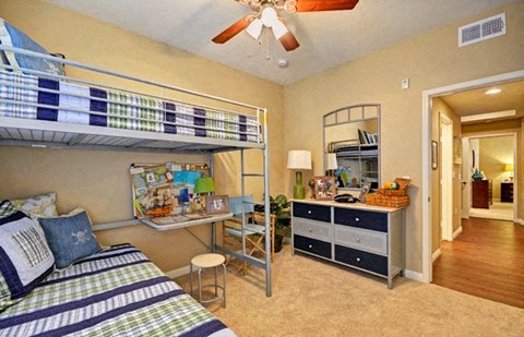 A bedroom with a bunk bed and a dresser.