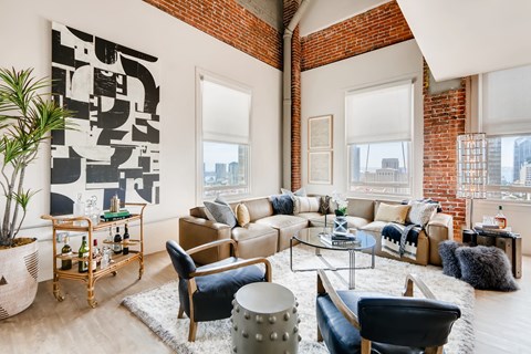 A living room with a large sofa set and a large abstract painting on the wall.