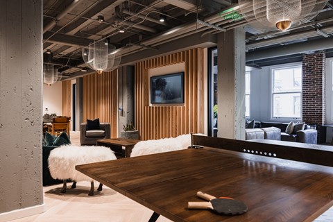 a room with a ping pong table and couches