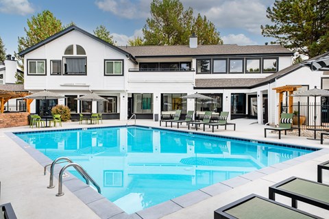A large white house with a pool in the backyard.