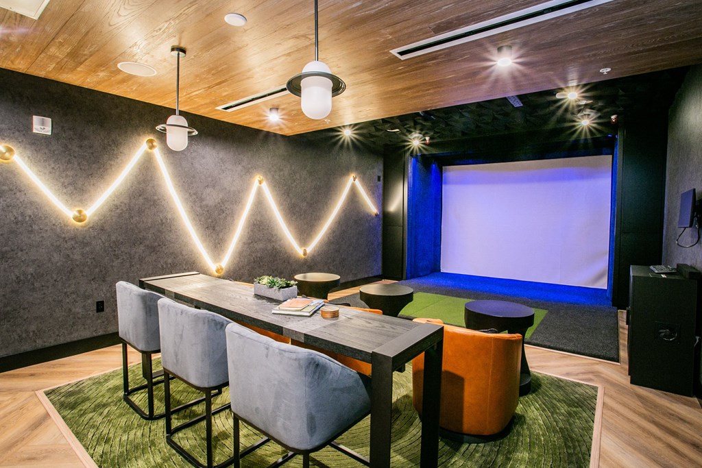 a large table with chairs and a projection screen in the background