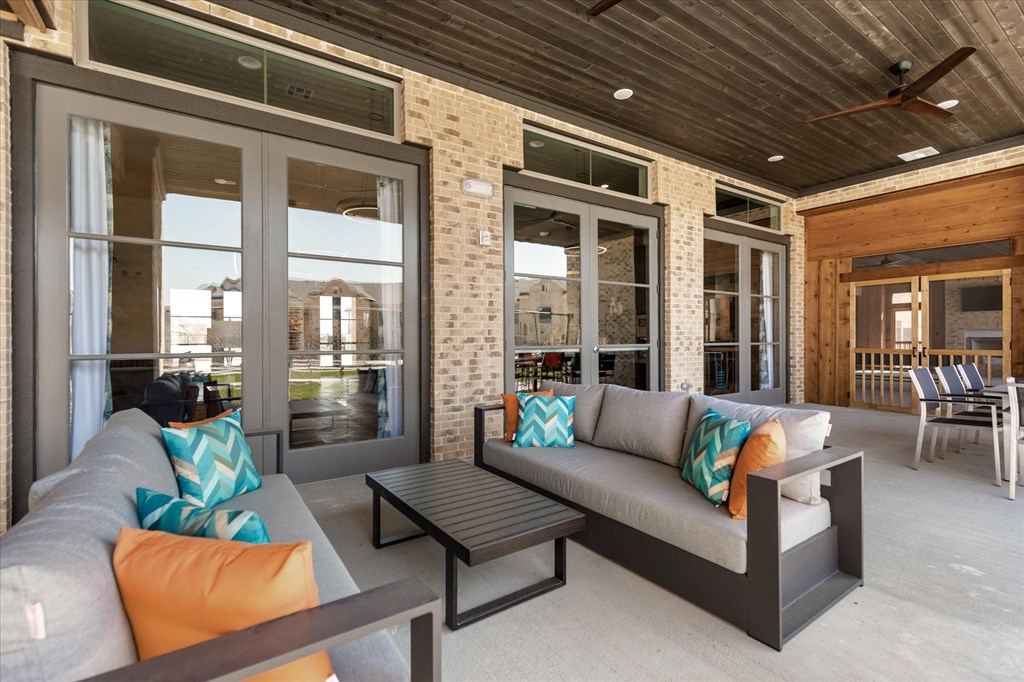 a covered patio with couches and a coffee table