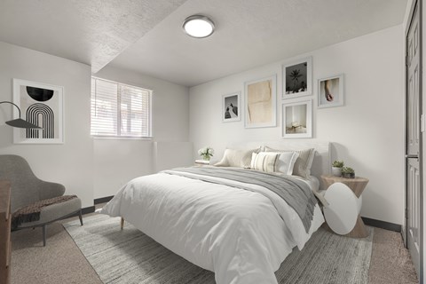 Spacious apartment bedroom featuring carpet flooring, natural light window, and closet at The Pointe at Northridge in North Salt Lake, UT