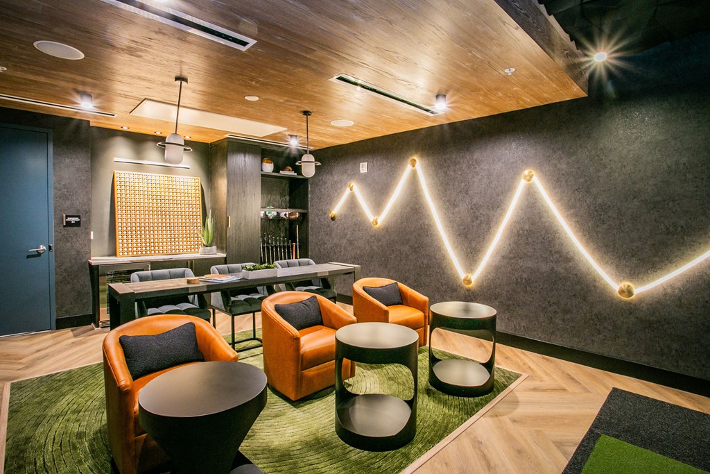 a room with orange chairs and a green rug stream of light across the wall.