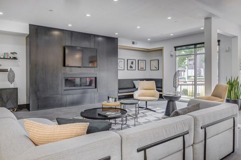 A modern living room with a grey sofa and a black fireplace.
