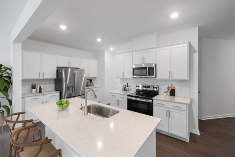 A modern kitchen with white cabinets and a marble countertop.