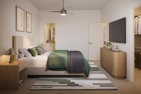 A bedroom with a bed, a nightstand, a dresser, and a TV mounted on the wall.