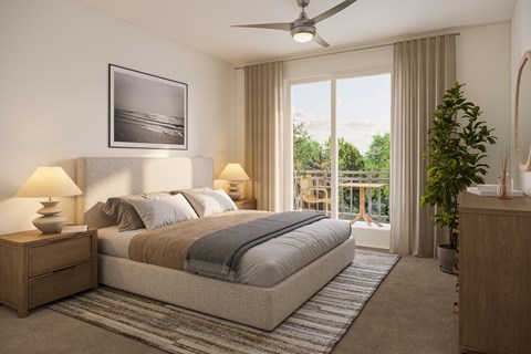 A bedroom with a large bed, a ceiling fan, and a balcony overlooking a garden.