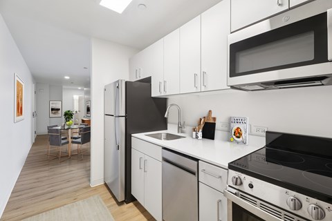 A modern kitchen with stainless steel appliances and white cabinets.