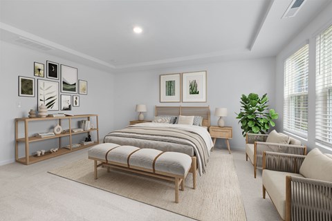 A bedroom with a bed, a chair, and a plant.