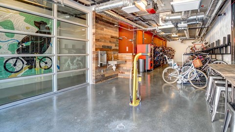 A room with a bicycle rack and a mural on the wall.