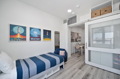 a bedroom with a bunk bed and a door to a bathroom