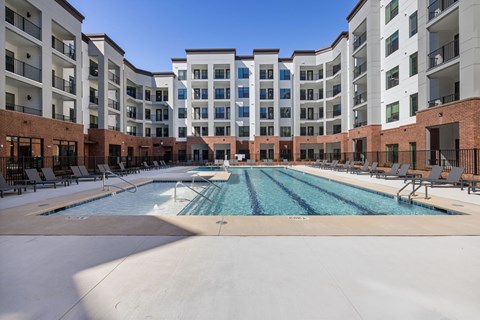 A large swimming pool in front of apartment buildings.