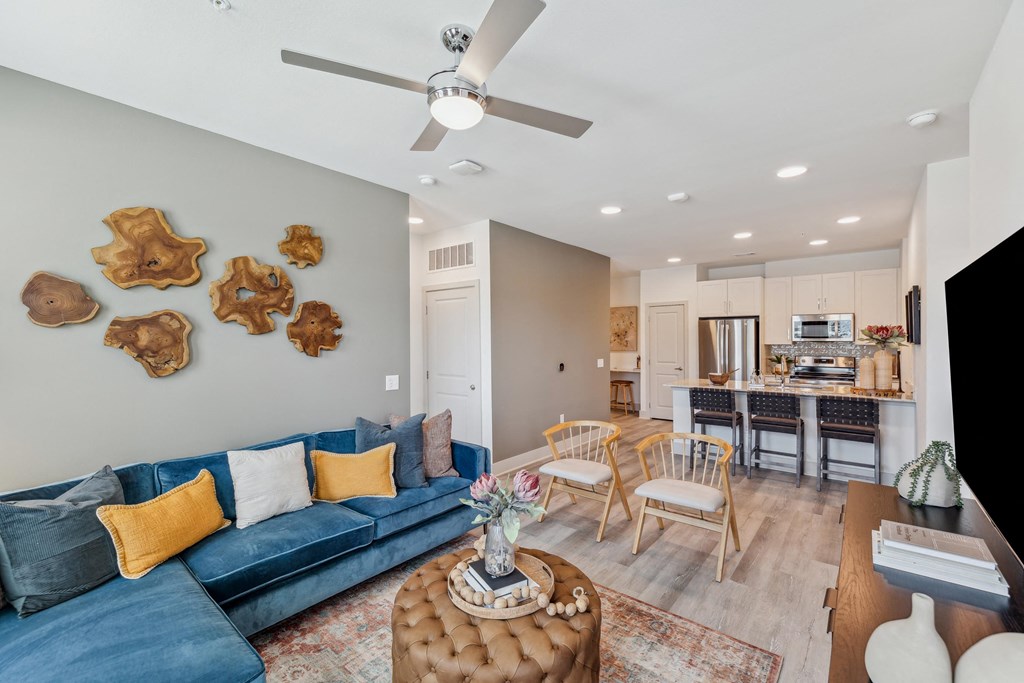 a living room with a blue couch and a kitchen with a table and chairs