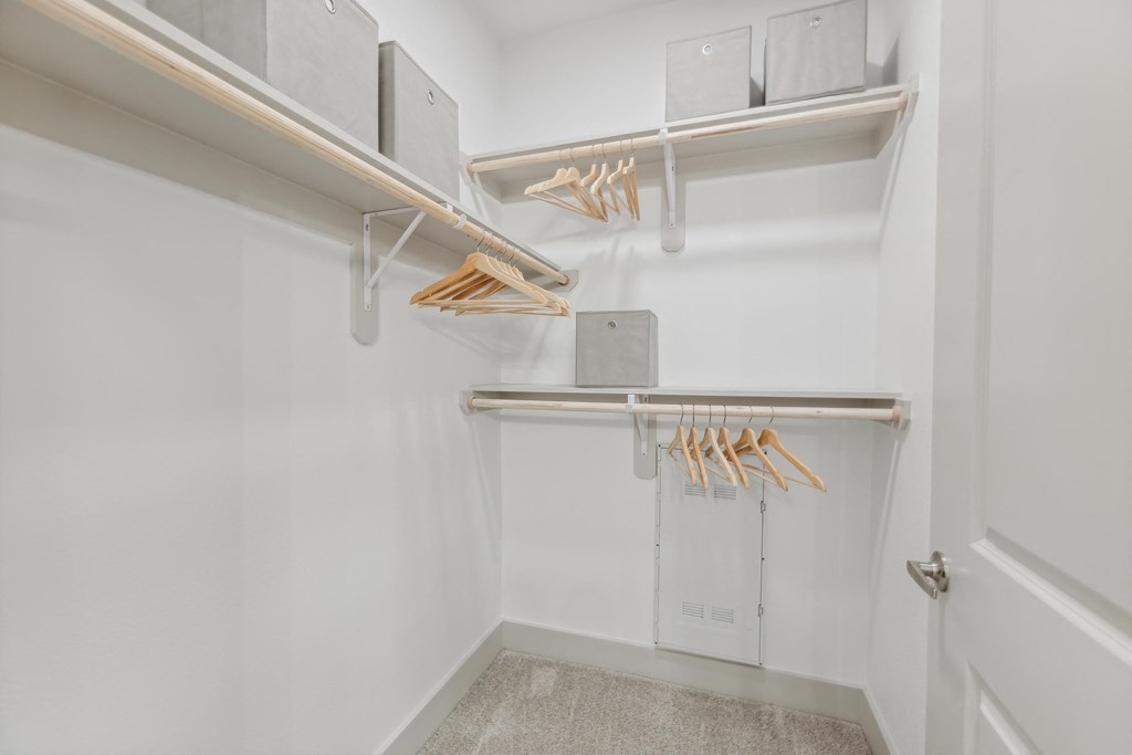 a walk in closet with white walls and a white door