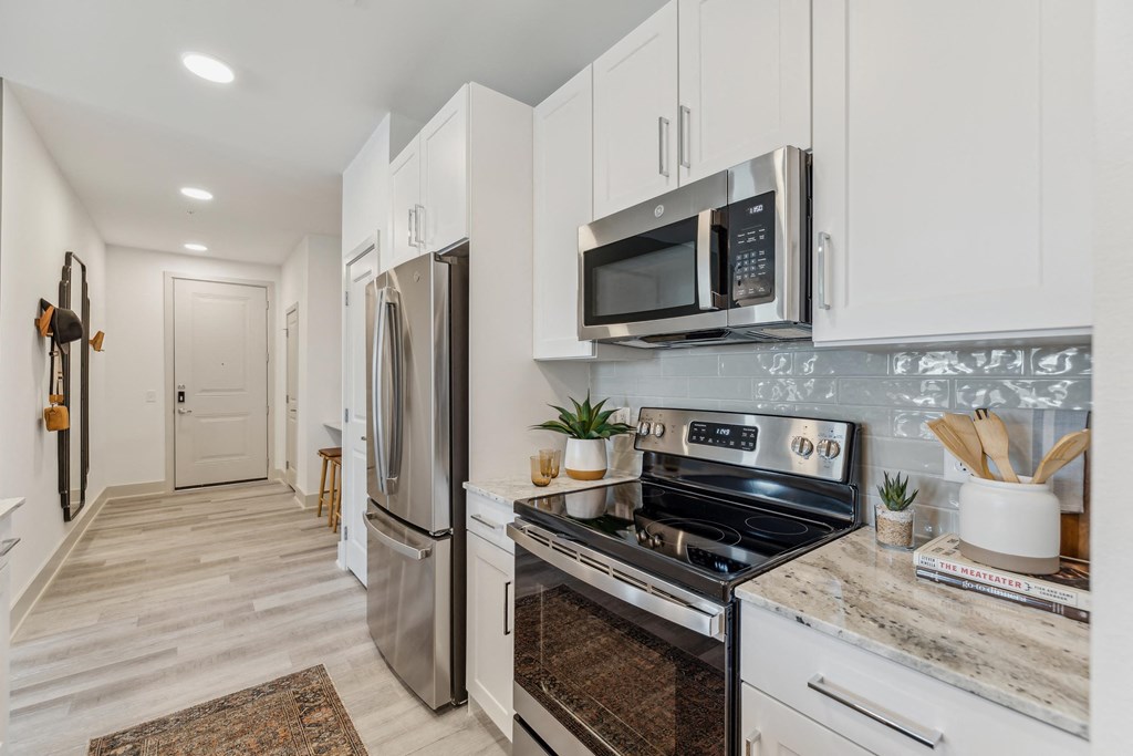 a kitchen with stainless steel appliances and white cabinets