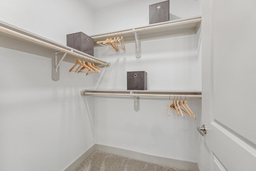 a walk in closet with white walls and a white door