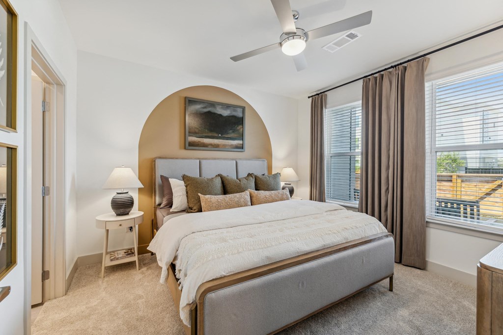 a bedroom with a bed and a ceiling fan