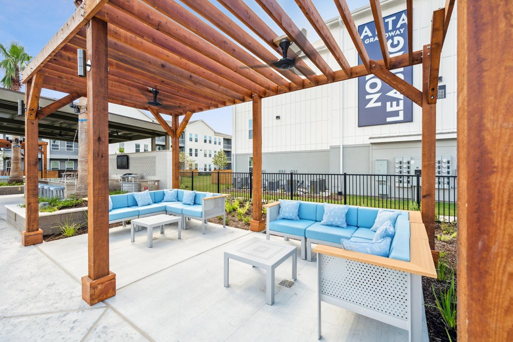 a patio with couches and tables and a pergola