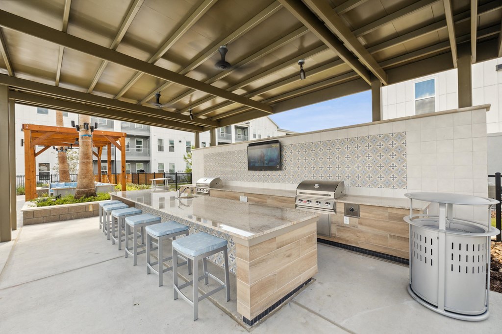 a large outdoor kitchen with a bar and stools