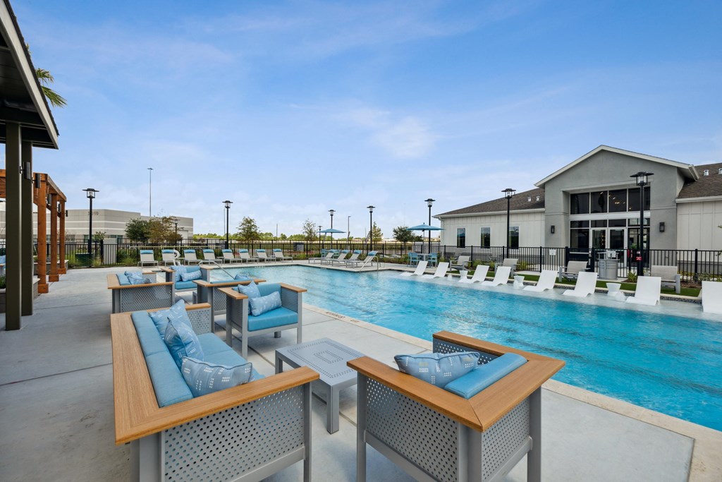 a swimming pool with lounge chairs and tables at the resort