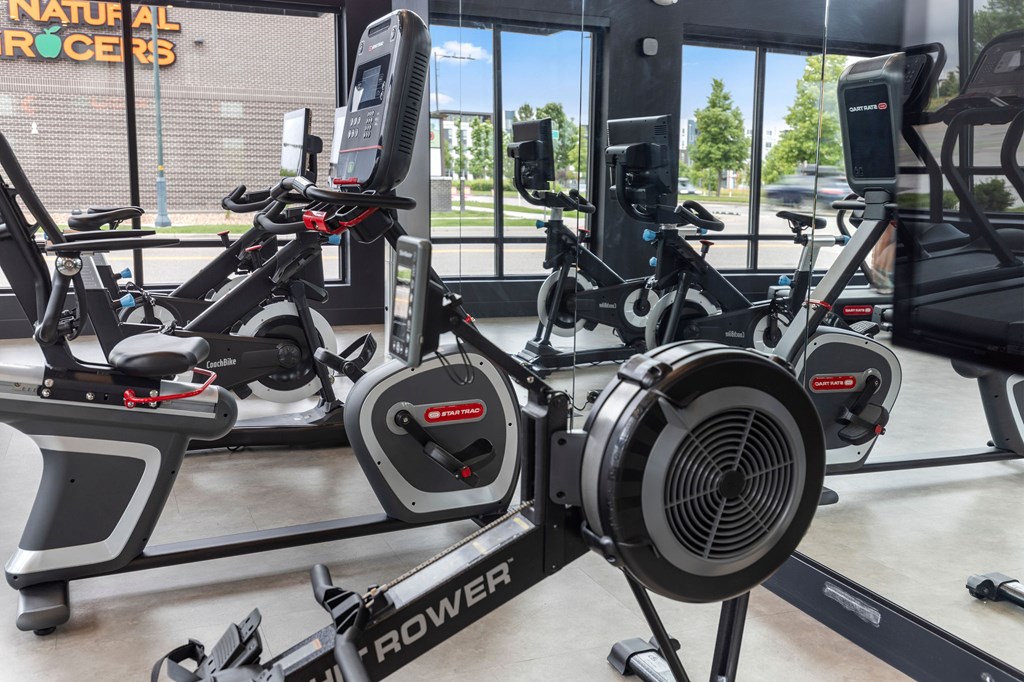 A gym with a row of stationary bikes.