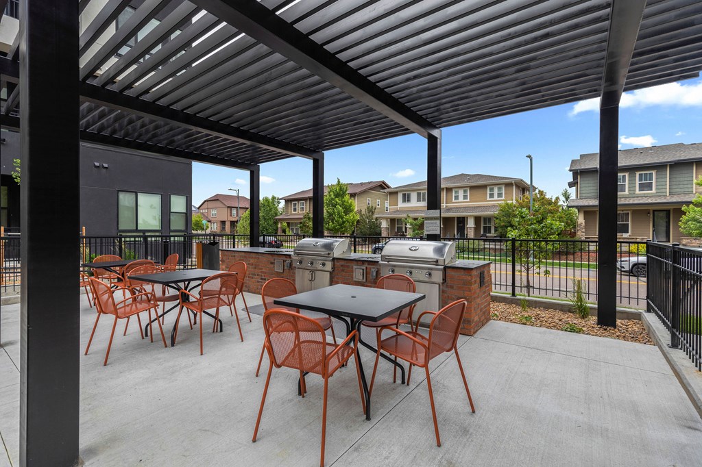 A patio with a table and chairs under a roof.