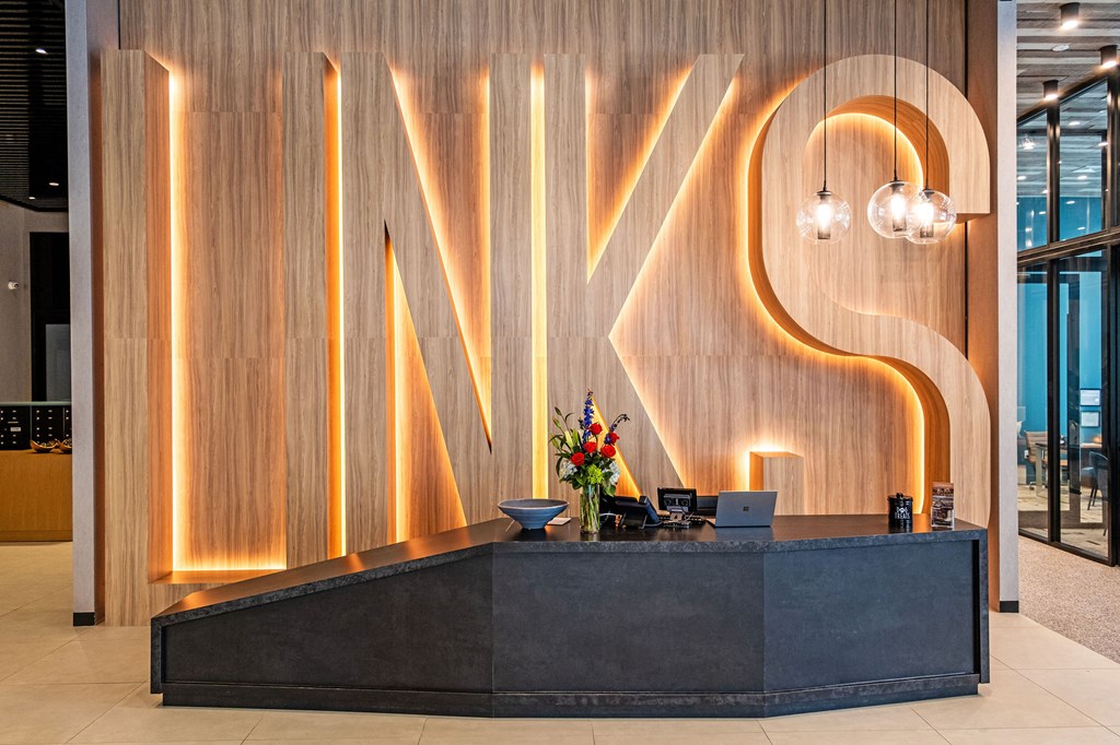 A reception desk with the word "LINKS" illuminated in neon lights.