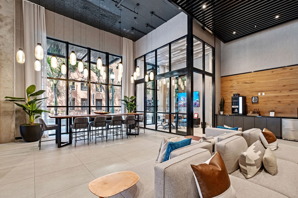 A modern living room with a large window and a wooden ceiling.