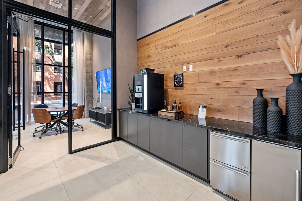 A modern kitchen with a wooden wall and stainless steel appliances.