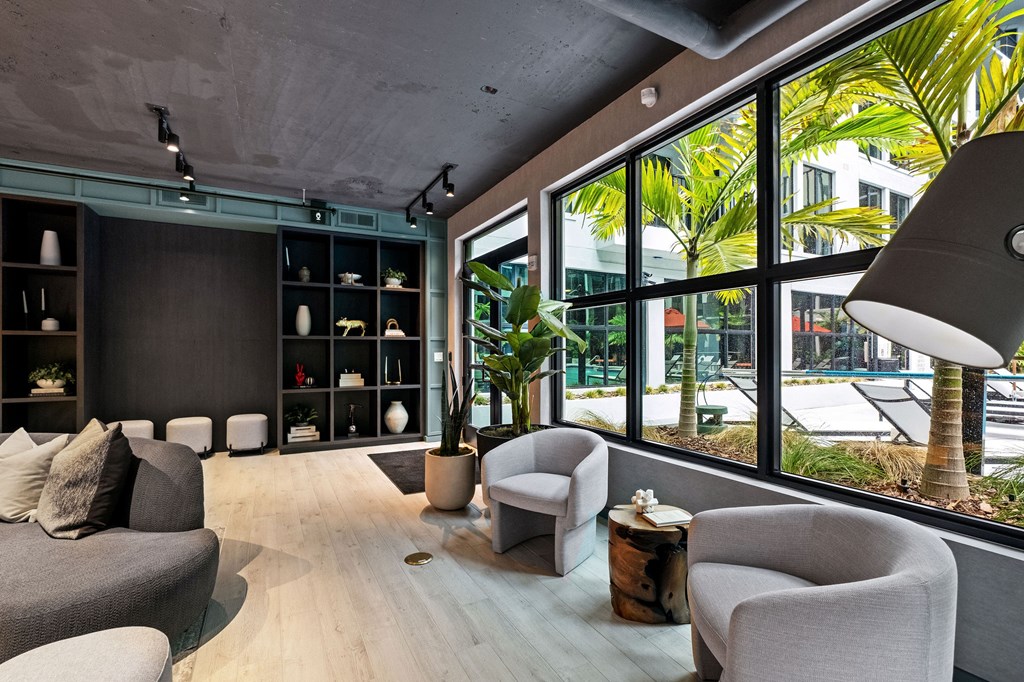 A modern living room with a grey sofa, armchairs and a wooden coffee table.