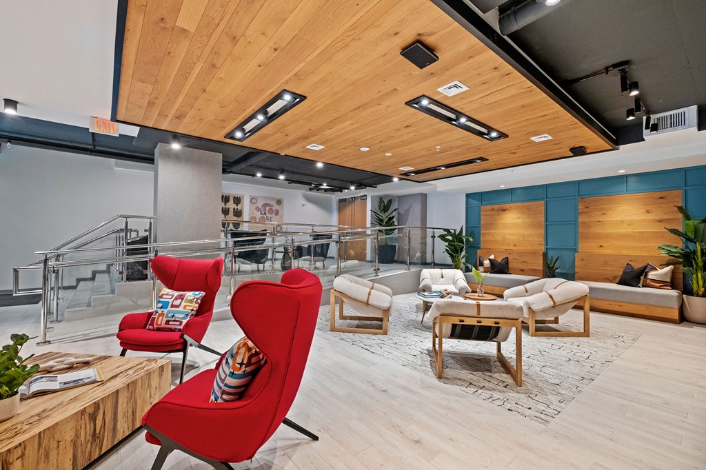 A modern living room with a red chair and wooden furniture.