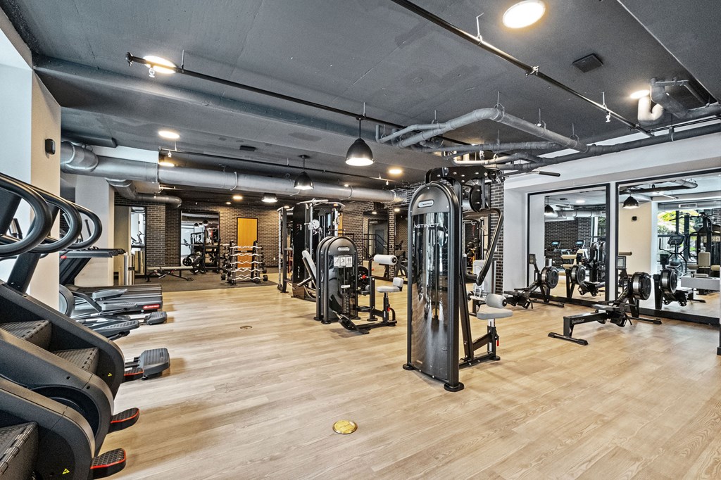 A gym with treadmills, weights, and exercise equipment.