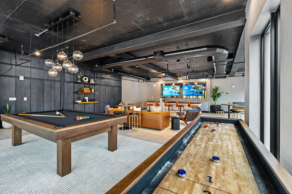 A pool table is in the middle of a room with a TV and a couch.