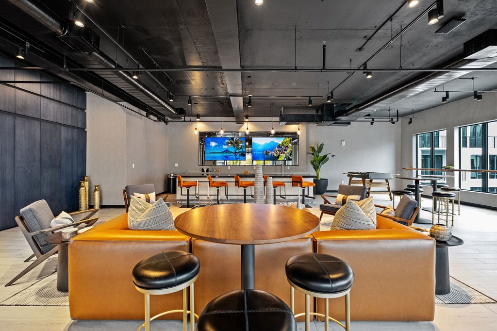 A modern lounge area with a large TV screen at the back.