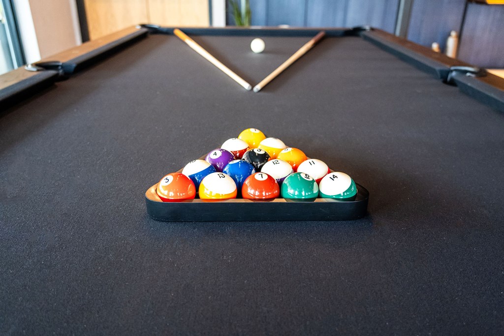 A pool table with a variety of balls lined up in a triangle.