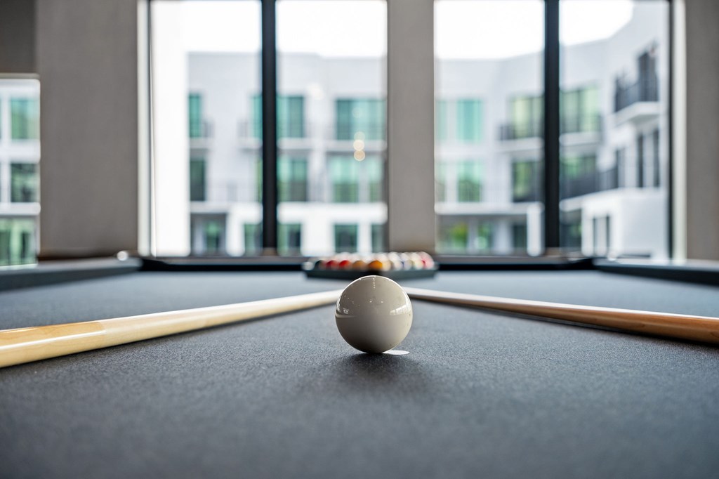 A pool table with a white ball in the middle of it.