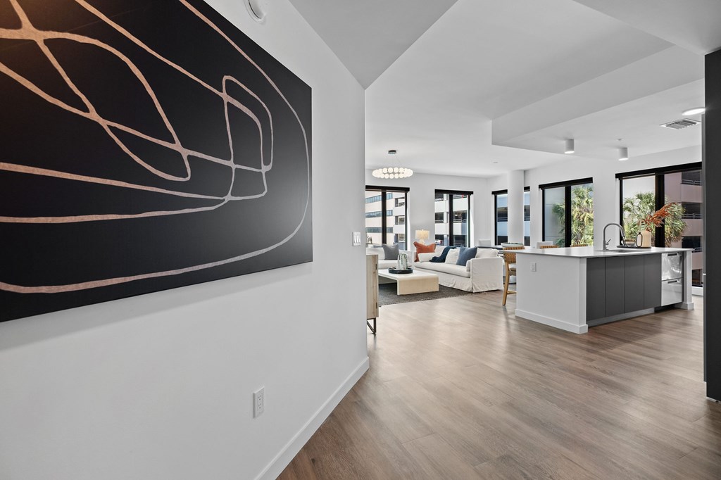 A modern living room with a large abstract painting on the wall.