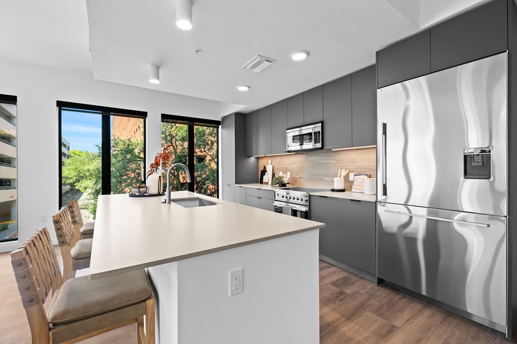 A modern kitchen with a large island and stainless steel appliances.