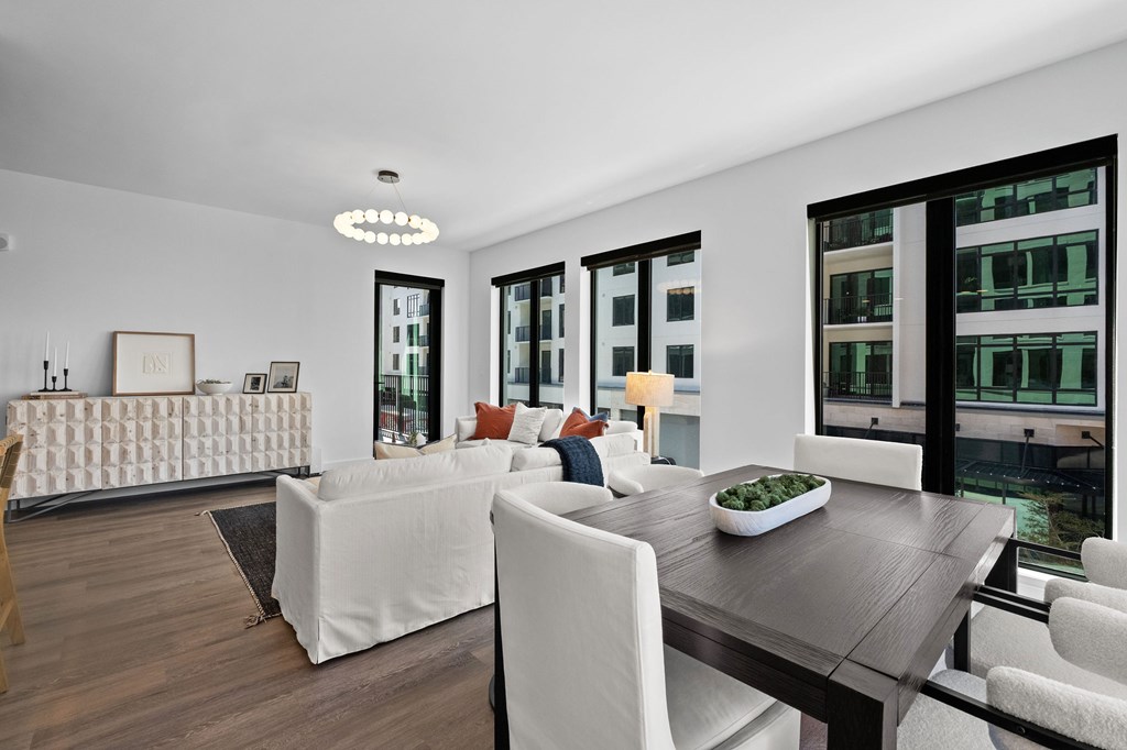 A modern living room with a wooden floor and white furniture.
