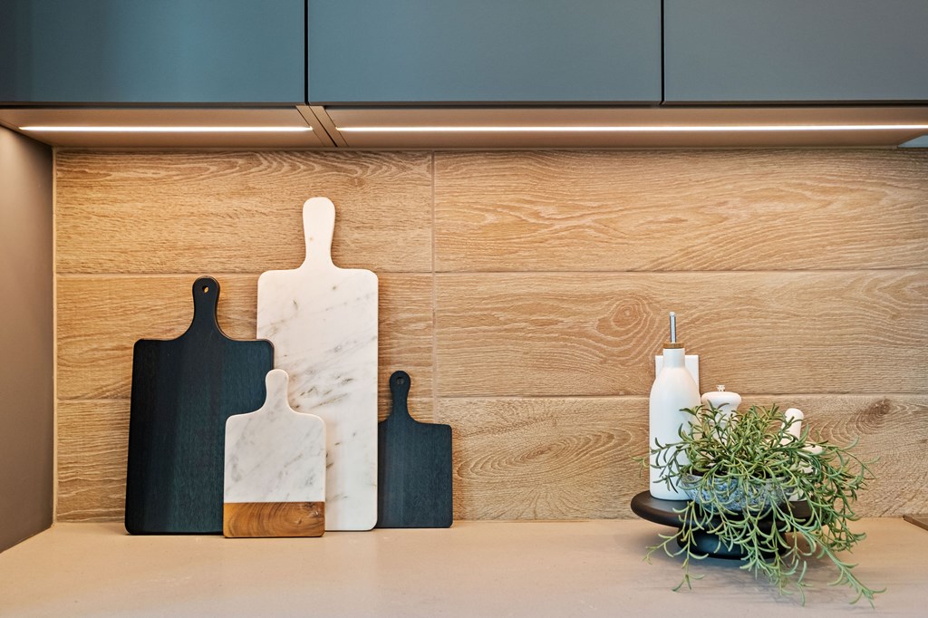 A set of cutting boards and a plant on a counter.